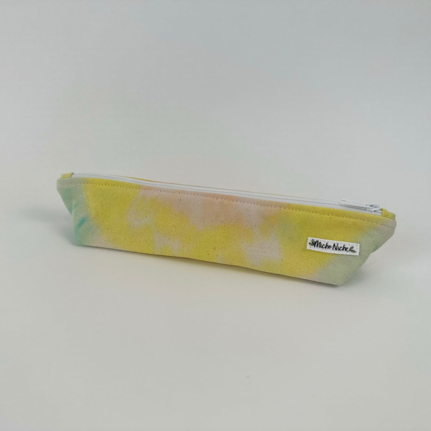 Miche Niche zipper pouch in a hand dyed pastel yellow, green, and pink tie dye pattern