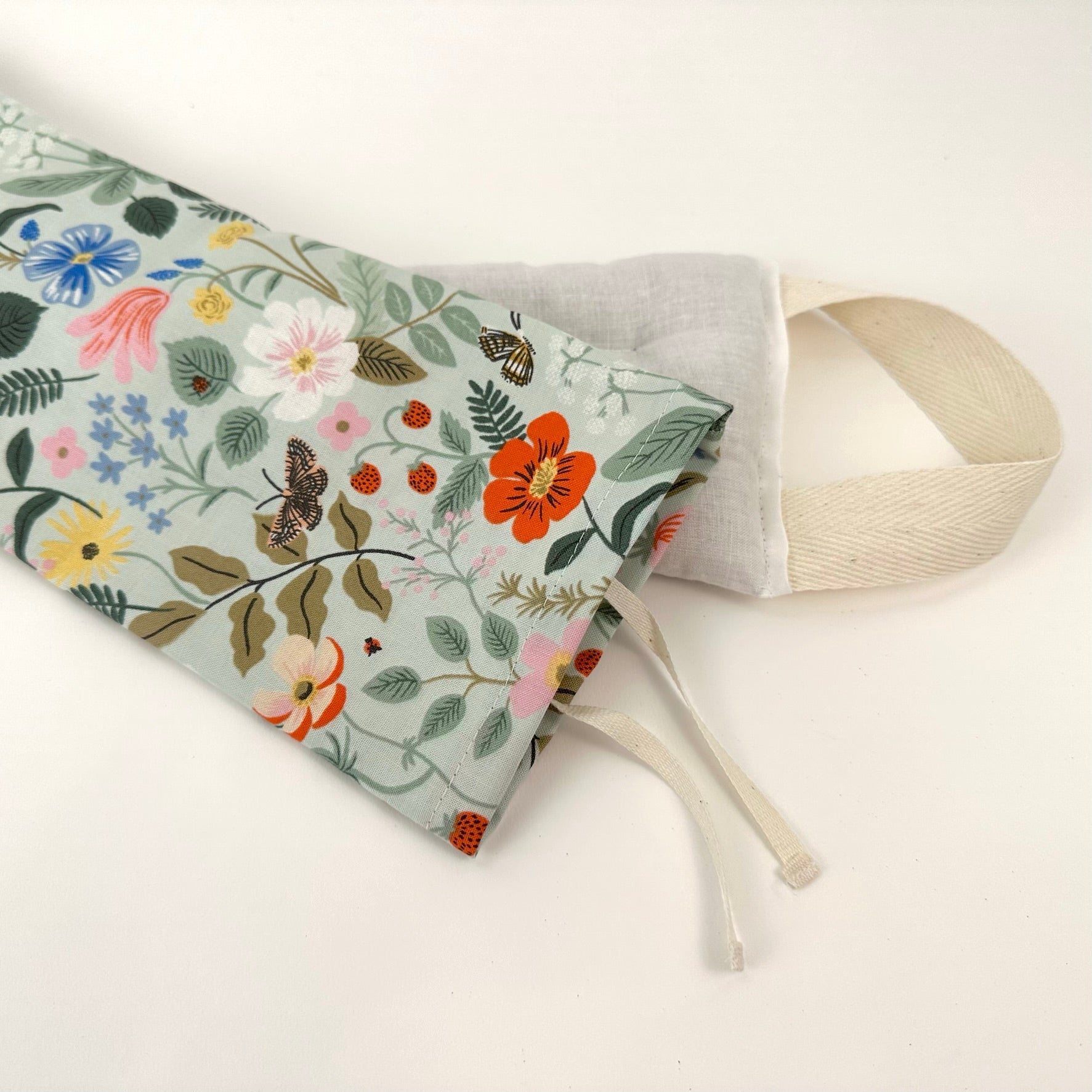 Miche Niche Lavender Neck Wrap in Rifle Paper Co's Strawberry Feilds pattern demonstrating the product's washable, removable cover