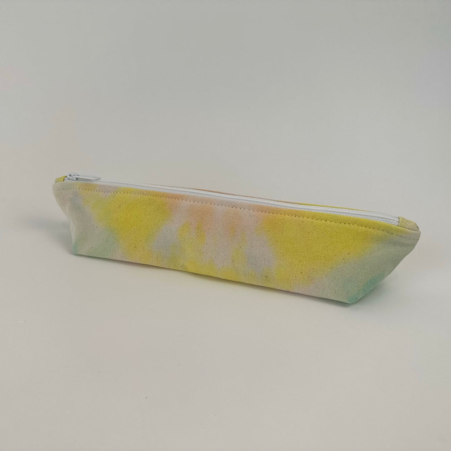 Back view of a Miche Niche zipper pouch in a hand dyed pastel yellow, green, and pink tie dye pattern