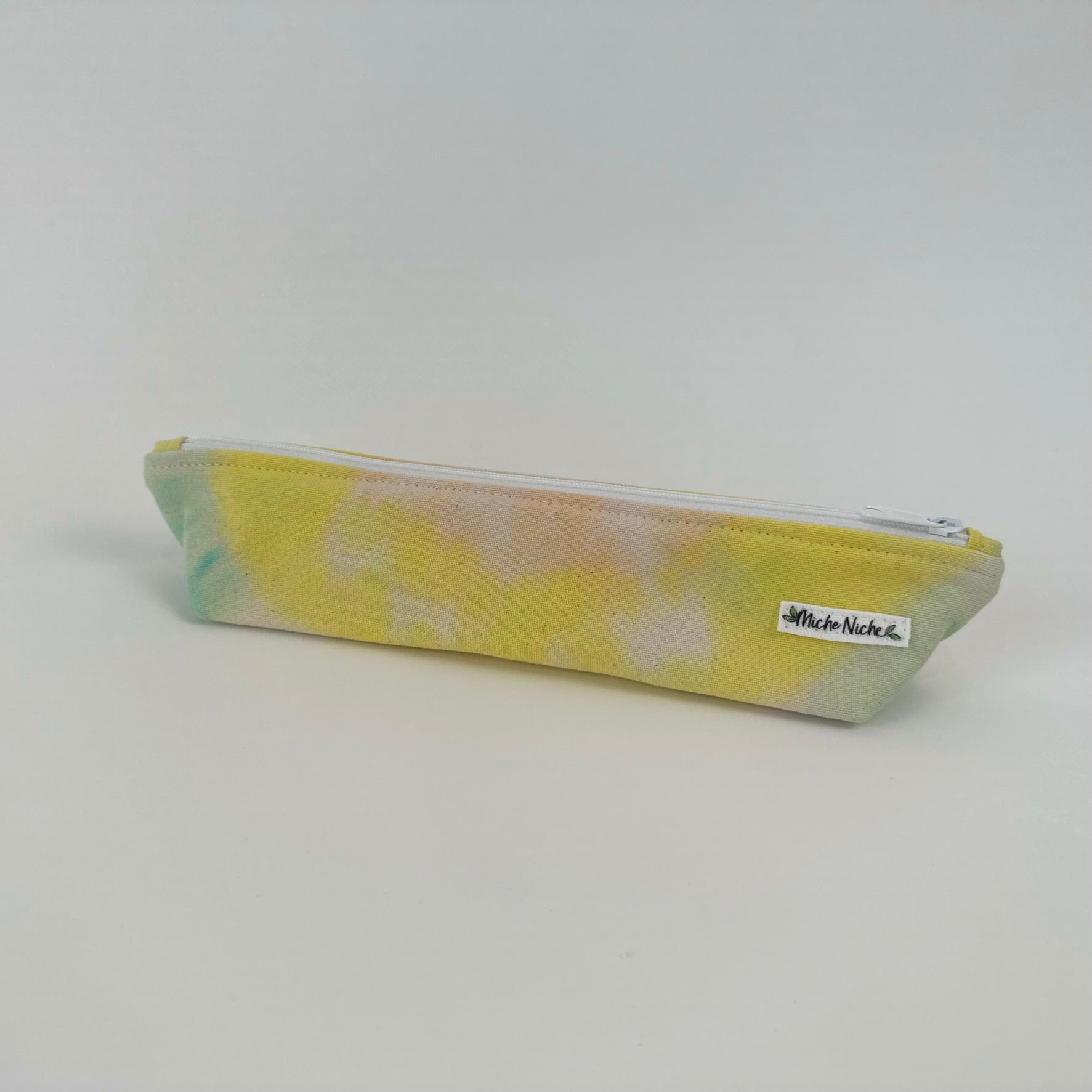 Miche Niche zipper pouch in a hand dyed pastel yellow, green, and pink tie dye pattern