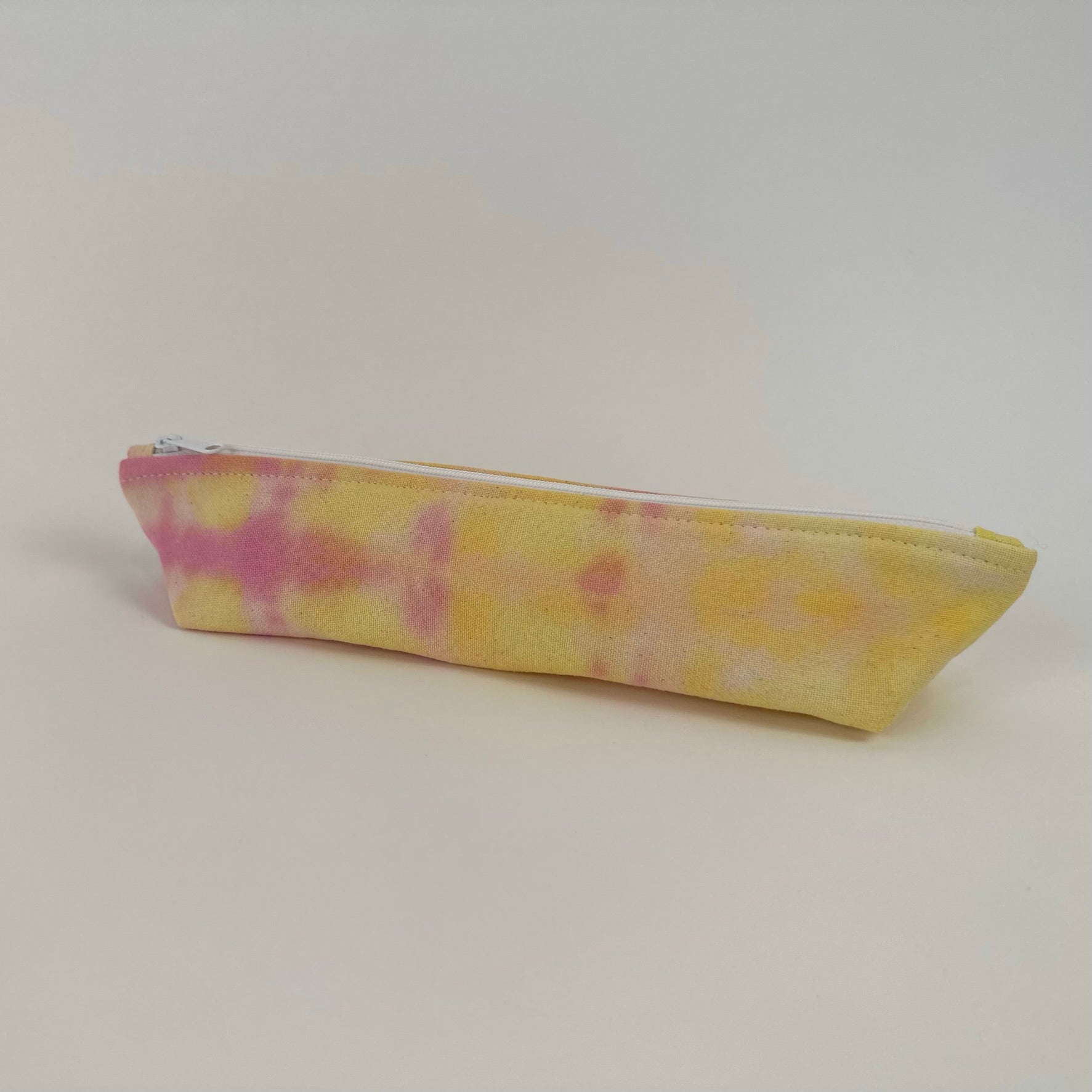 Back view of a Miche Niche zipper pouch in a hand dyed pink and yellow tie dye pattern