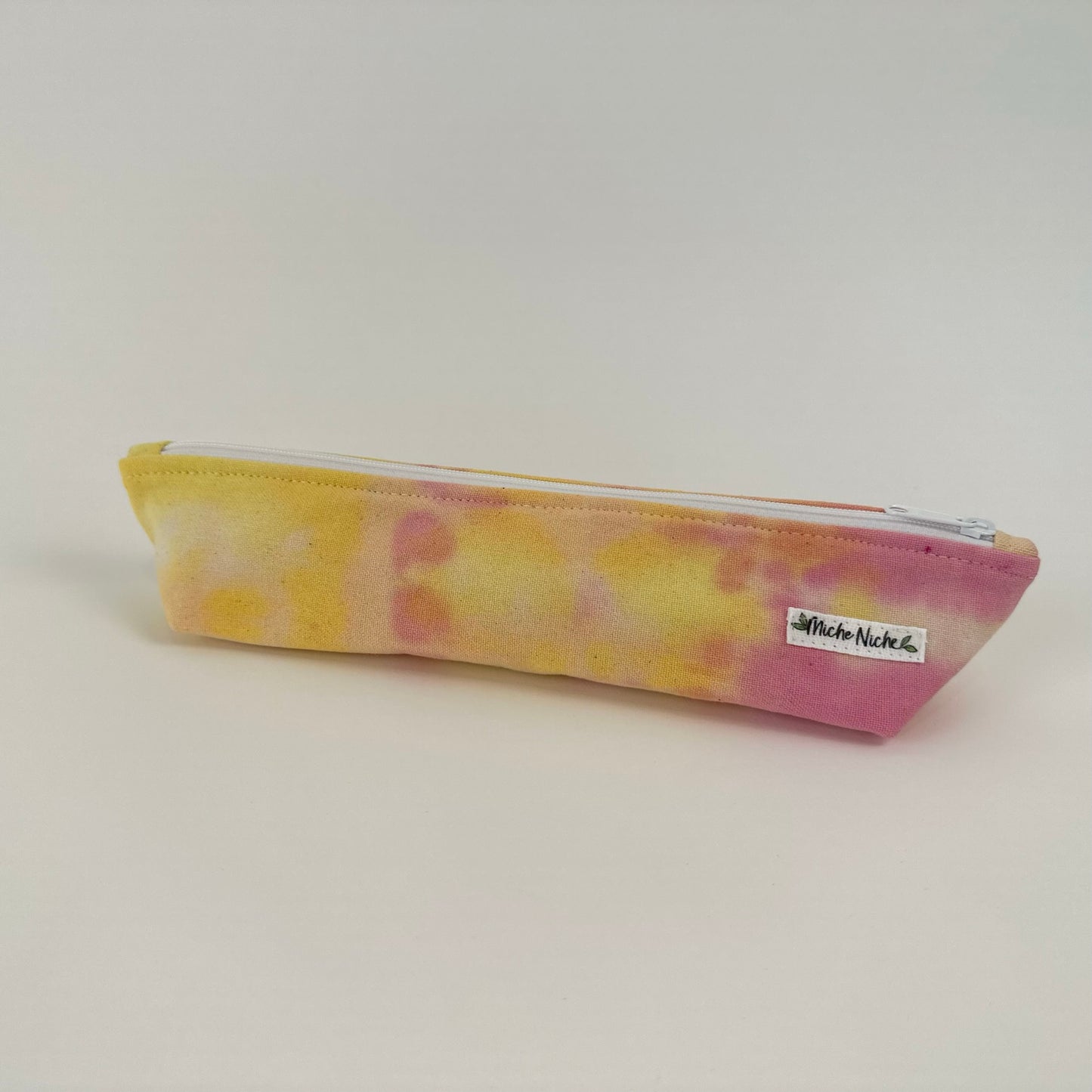 Miche Niche zipper pouch in a hand dyed pink and yellow tie dye pattern