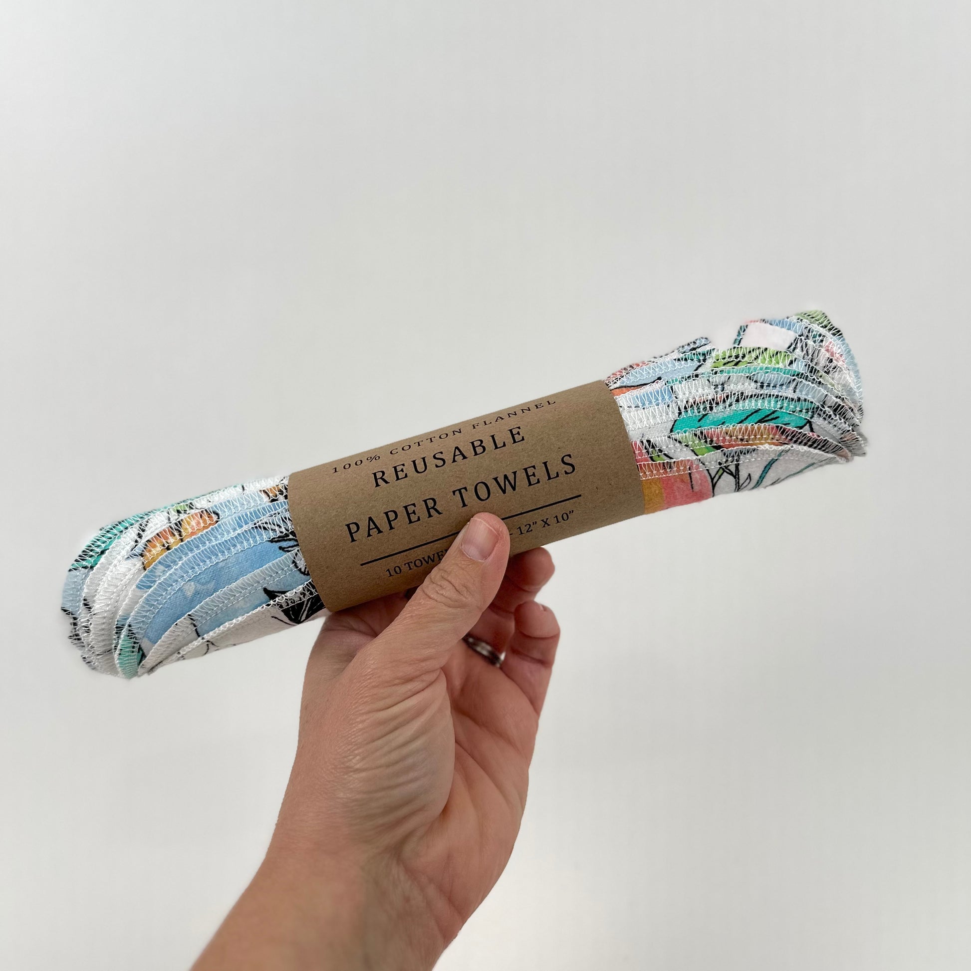 A roll of felt paper towels printed with a pattern of water colored flowers in shades of peach, blue, and green - part of the Miche Niche Reusable Paper Towel collection