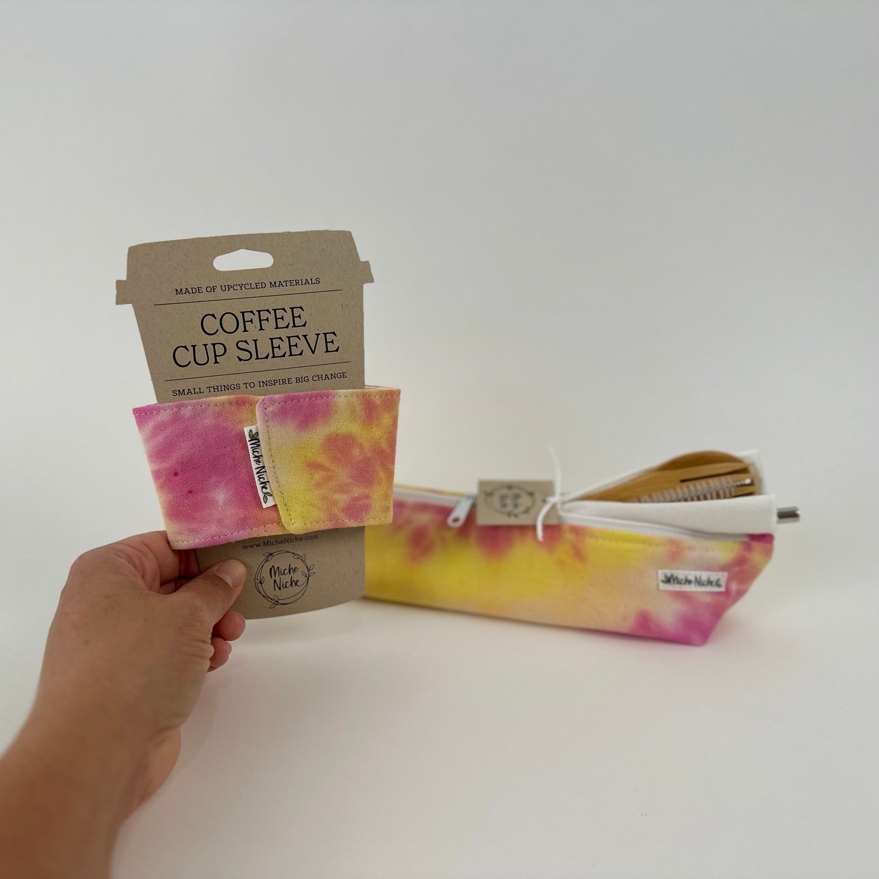 Matching set of Miche Niche coffee cup sleeve and zipper pouch in a hand dyed tie due pattern of pink, yellow, and fuchsia