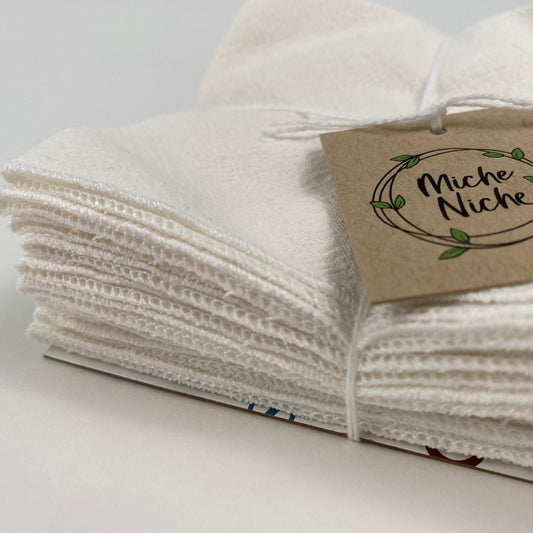 Closer view of the surged edge of Miche Niche every day reusable napkins with a white napkin and white edge stitching.